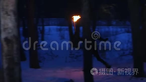 一个年轻的被吓坏了的女人，手里拿着火炬从森林里跑出来