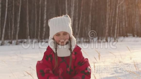 快乐的小女孩在空中撒雪，微笑着