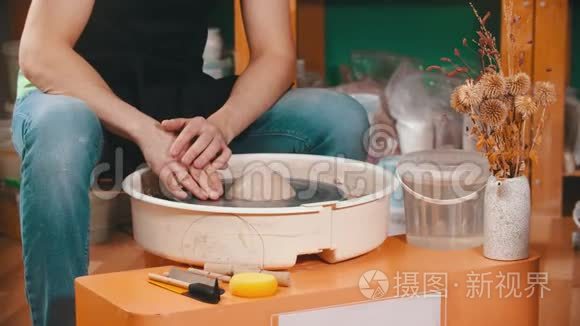 陶器-主人打开陶工`轮子，正在看黏土