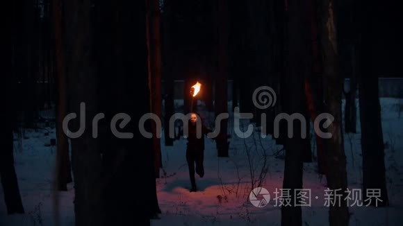 夜冬森林里火炬传递的年轻女子视频