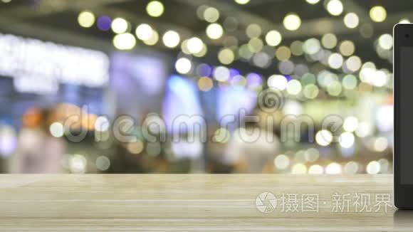 现代智能手机屏幕上的购物车平面图标，在木制桌子上，在购物中心模糊的光影上，商务