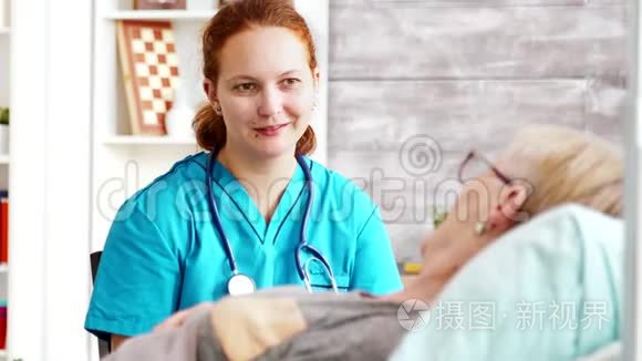 一张女助手与躺在病床上的老太太谈话的照片