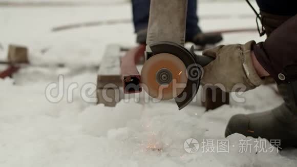 用电锯锯掉金属型材.. 男人`手在雪地里用电动工具切断金属型材