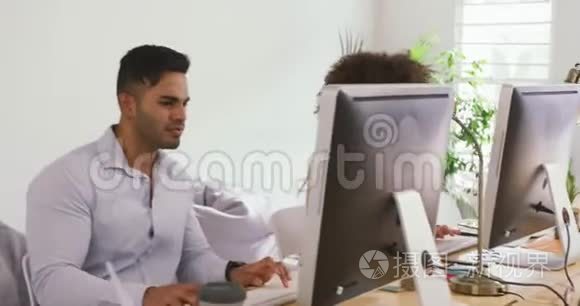 两位同事在创意办公室工作电脑视频