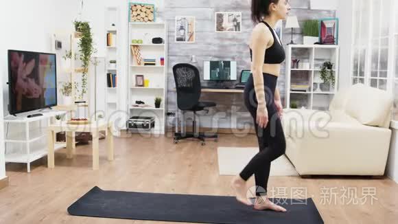 安静的年轻女性在客厅练习瑜伽视频