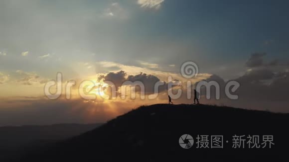 父子俩在美丽的夕阳下登上山顶视频