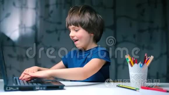 男孩用手轻敲笔记本电脑键盘.