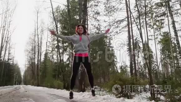 女人做跳跃千斤顶作为在森林中锻炼新鲜空气。 低角度视角和慢运动..