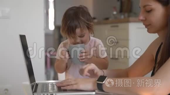 在家工作的年轻女子带着小孩。 妈妈家庭办公室快乐