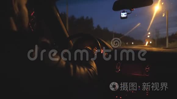 男司机握着方向盘，晚上在高速公路上骑汽车。 他开着现代汽车