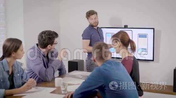 在办公室报到.. 一个人以自己的方式为同事做演讲。 商业幻灯片显示在电视上。