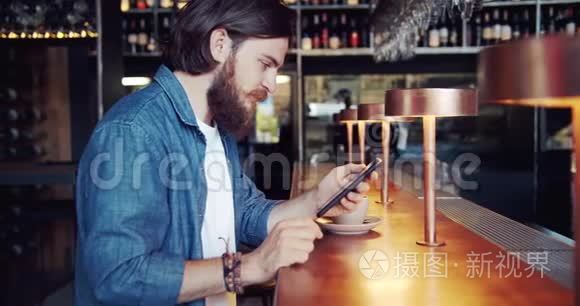 男性在酒吧浏览智能手机视频