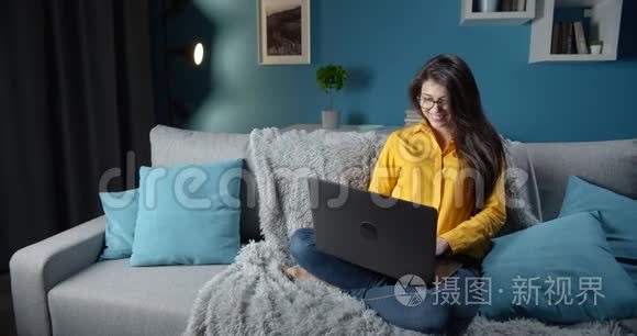 漂亮的女士在家放松，使用笔记本电脑