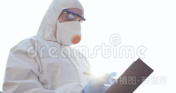 女医生病毒学家戴着面罩和西装站在外面并记下数据。 冠状病毒COVID-19