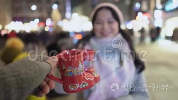 女人在圣诞城喝热饮料视频