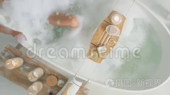 性感的女人在家洗澡。 放松的女孩躺在浴缸里用泡沫。