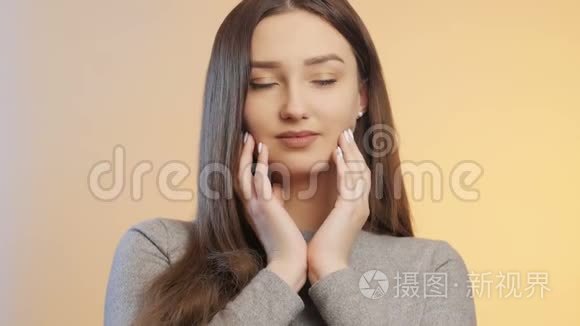 美丽可爱的女孩移动她的手指，等待一个粉彩画室的颜色背景，一个年轻的女人的脸化妆，这是。