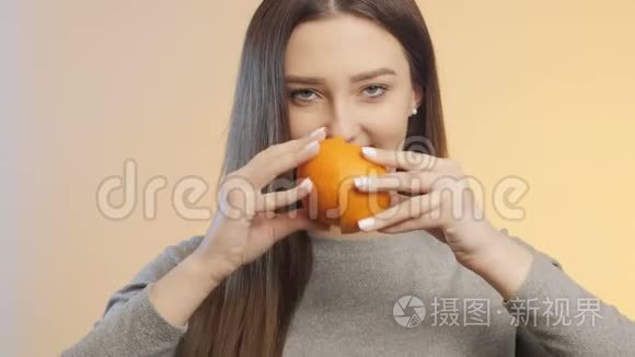 可爱的女孩互相摩擦一半的橘子，挤压果汁的过程，健康饮食的概念和生活方式