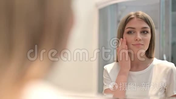 镜中美丽女性面部按摩的后景视频