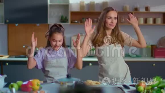 快乐的女孩和女人像机器人一样慢动作在厨房里跳舞