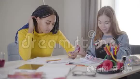 积极的白种人女孩拿着朋友的钢笔微笑。 在室内学习的年轻学生。 生活方式教育学习