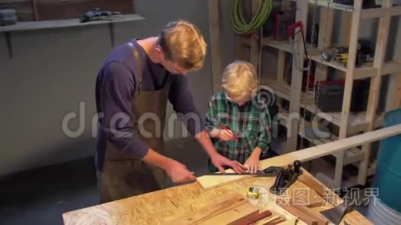 男人和男孩在车间里用木板工作