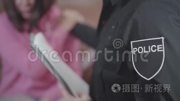 哭着的白种人女人在后台和警察说话。 男侦探牵着被害人`手