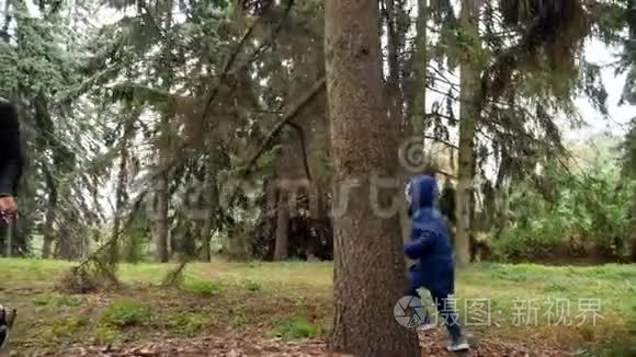 4k视频快乐的笑妈妈和小儿子在秋天公园的树间奔跑，互相追逐