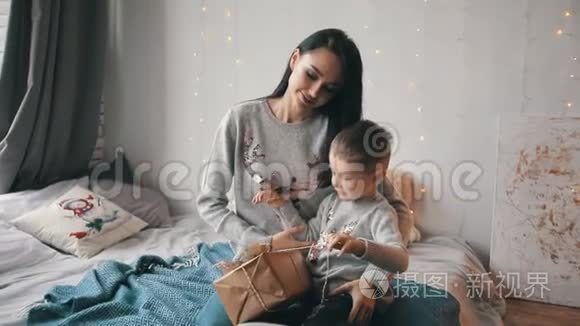 妈妈和儿子在床上打开一个礼品盒