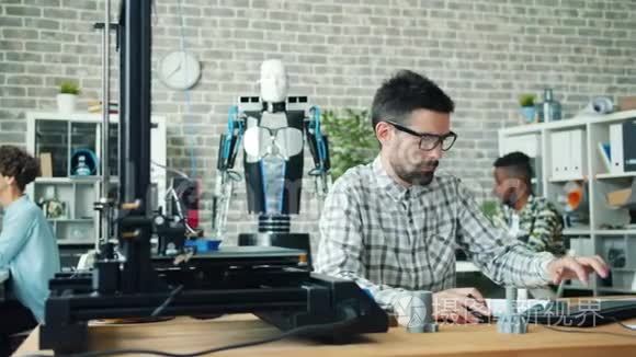 在办公室工作的女孩和男人用3d打印机和电脑制作机器人