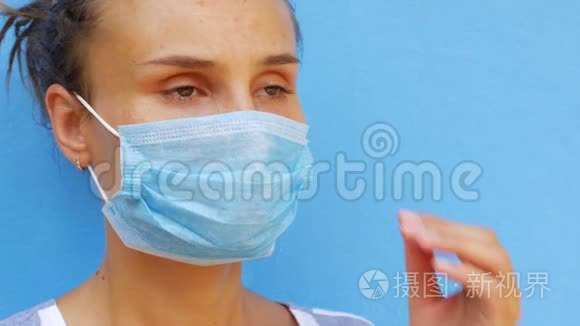一个戴着面具的年轻女人用纸巾吹鼻子。