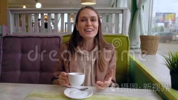 女性坐在咖啡馆里和镜头交谈，从同伴`的POV拍摄。