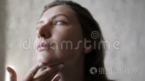 皮肤科，面部皮肤年轻化.. 女人擦面部化妆品。 每日奶油