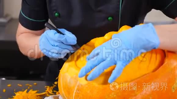 万圣节准备。 从南瓜千斤顶雕刻手套的特写镜头。 切割着耀眼的光芒