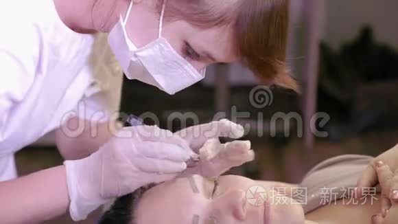 美容师用镊子矫正病人`眉毛。