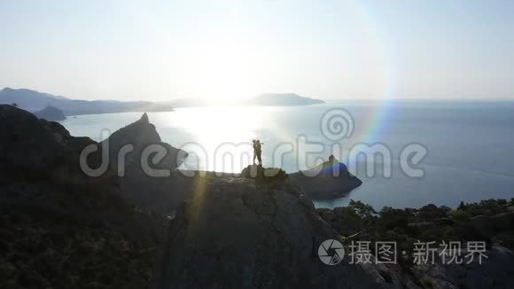 日出时，一对年轻的恋人站在山顶上亲吻着海面的空中轮廓。 飞行航班