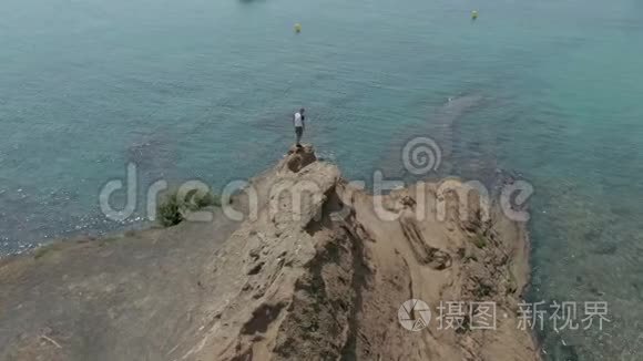 人站在碧海之上的悬崖上视频