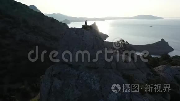 日出时站在山顶上的一个女孩围绕着一个动态的飞行。 年轻活跃女性的飞行