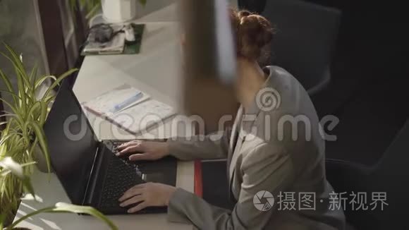 一位年轻的白人妇女坐在露天办公室里看着笔记本电脑屏幕。成功商人的肖像