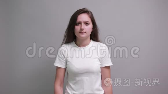 穿着时尚白衬衫的疲惫女人做停止姿势，把头放在手上