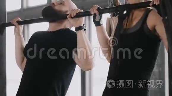 特写年轻快乐适合白种人男人和女人一起做下巴。 与个人健身教练一起锻炼。