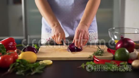 女人的手在厨房里切红洋葱