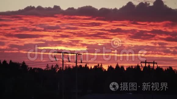 天空中发光的红色晚霞的高能量和下面地面的高压电力线。 太阳和太阳的能量