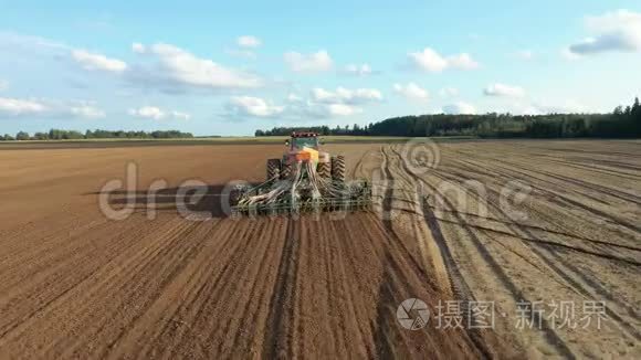 农民在拖拉机上播种农田土壤中的种子