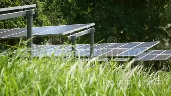 阳光明媚的日子，太阳能电池板覆盖草地。 草坪上的一排替代发电厂，产生生态能源。 养护