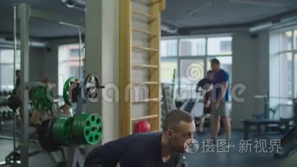 肌肉男在健身房用水壶做运动视频