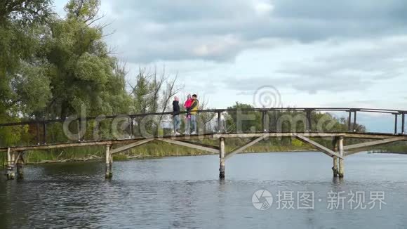 一家人沿着湖边的木桥散步