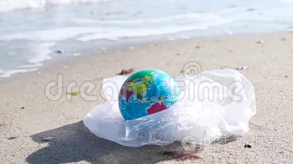 生态灾害概念。 阳光明媚的一天，海边一个塑料袋里装着全球球。