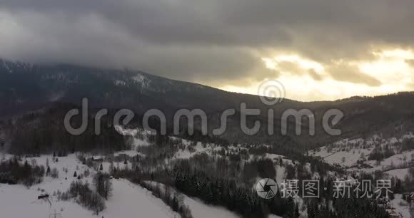 冬季日落时用雪覆盖的高山和森林的鸟瞰图