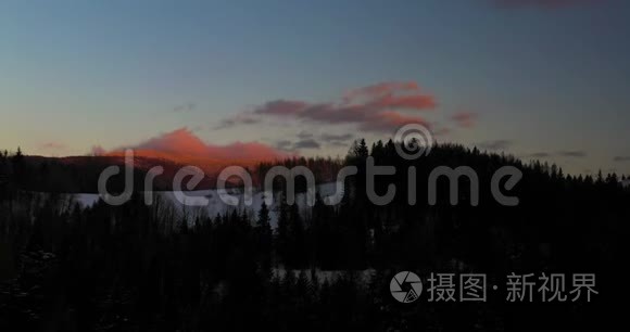 冬季日落时积雪覆盖的高山和森林的鸟瞰图